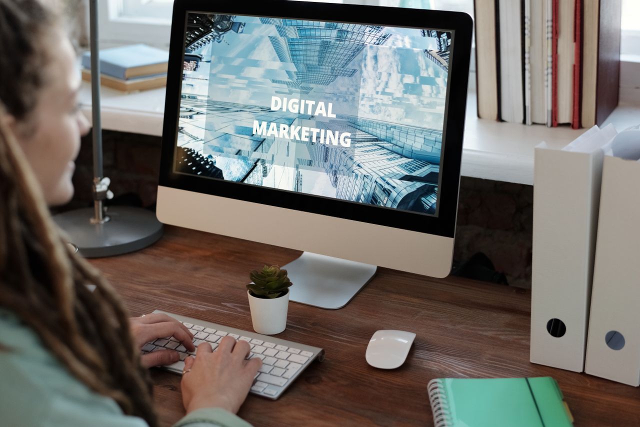 Vue rapprochée d’une femme travaillant sur un projet de marketing digital dans un bureau à domicile.